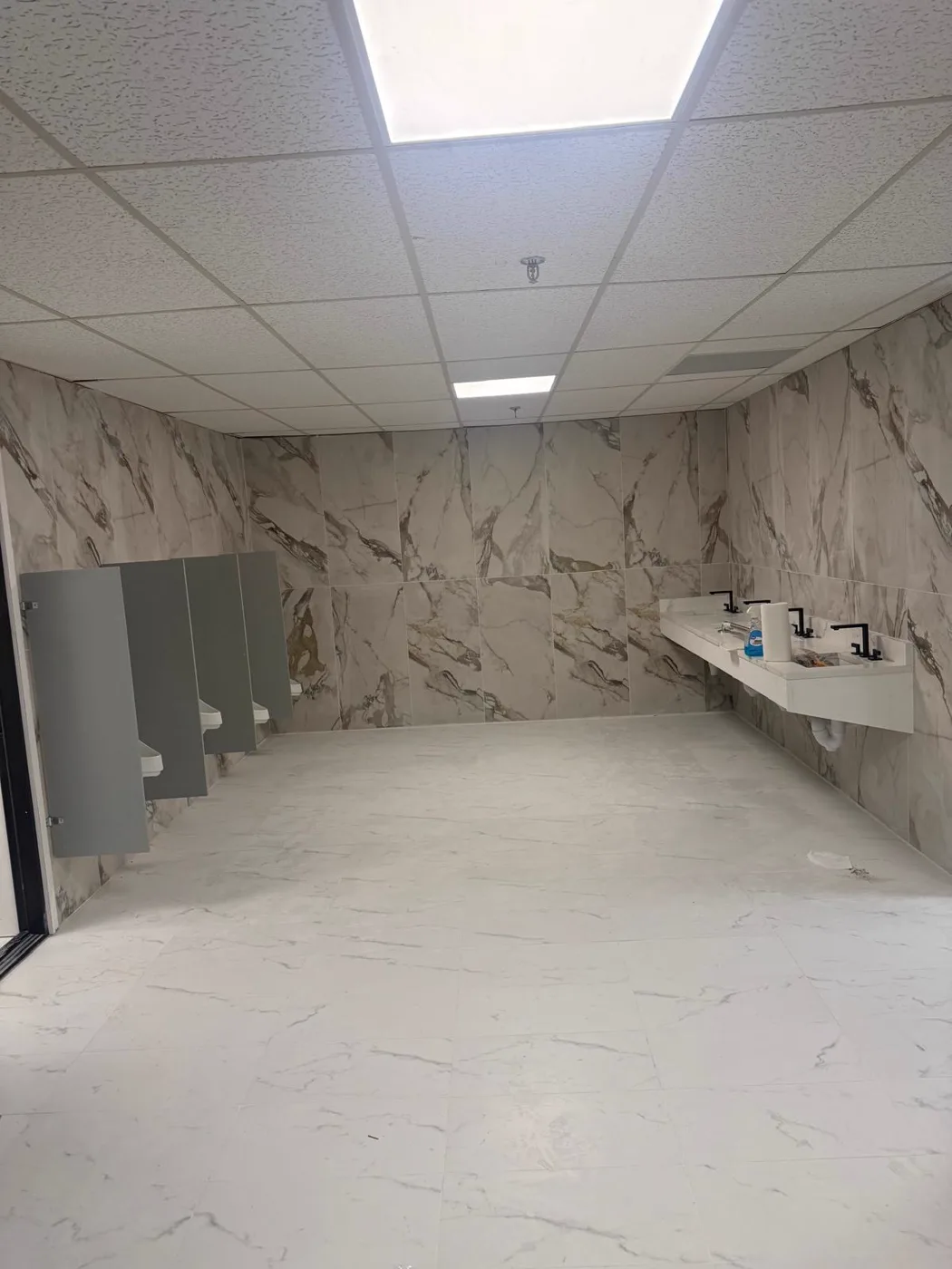 Baño comercial terminado con paredes de mármol y lavabos con cubierta de mármol, renovación de local, Metro Atlanta