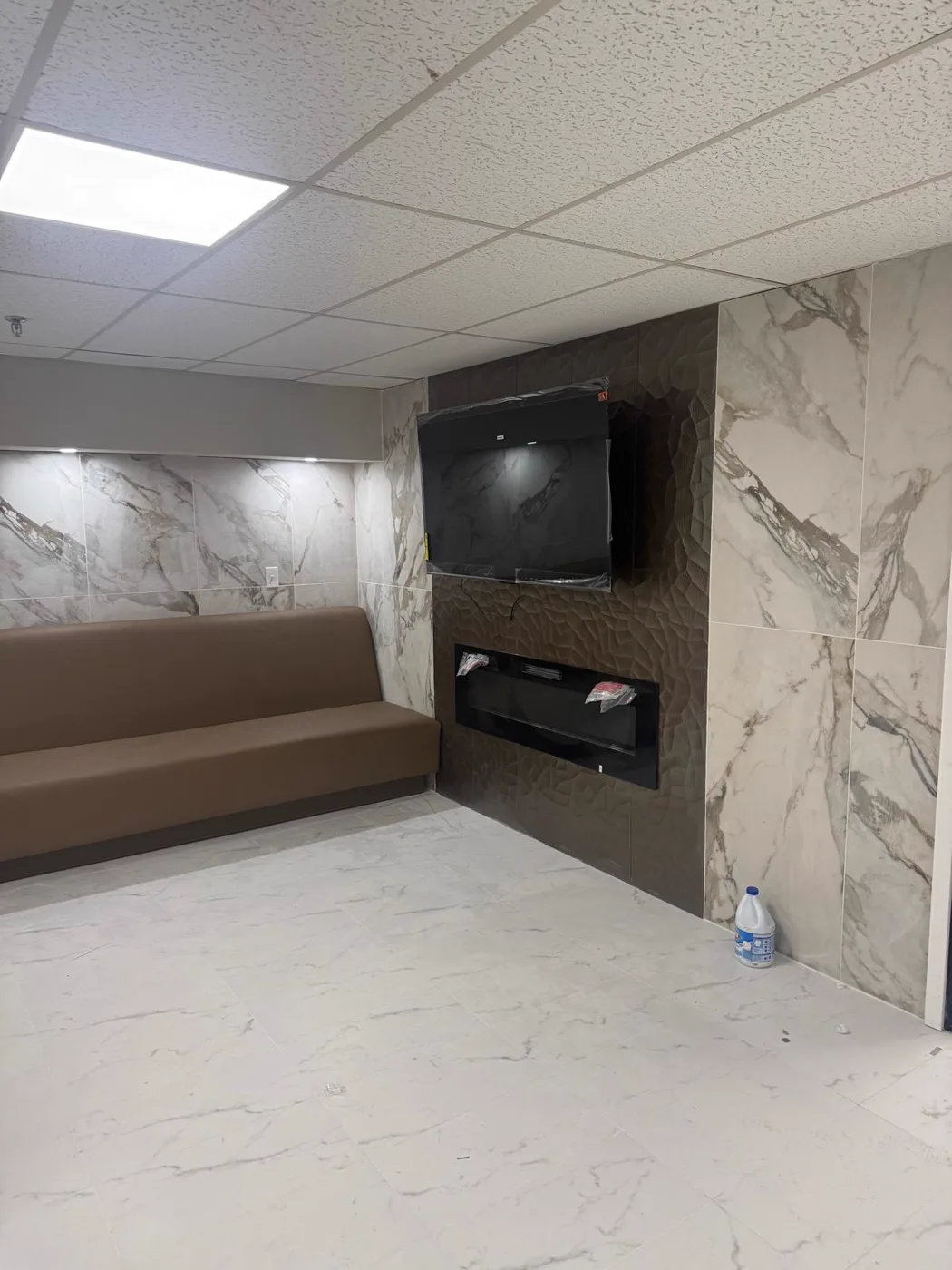 Área de espera terminada con paredes de mármol y sofá, renovación de un local comercial, Metro Atlanta