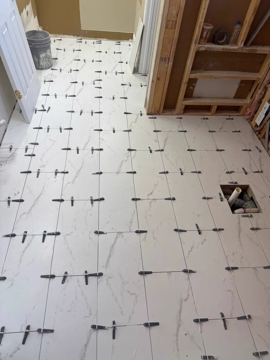 Azulejo de piso tipo mármol de formato grande colocado con separadores niveladores, Metro Atlanta
